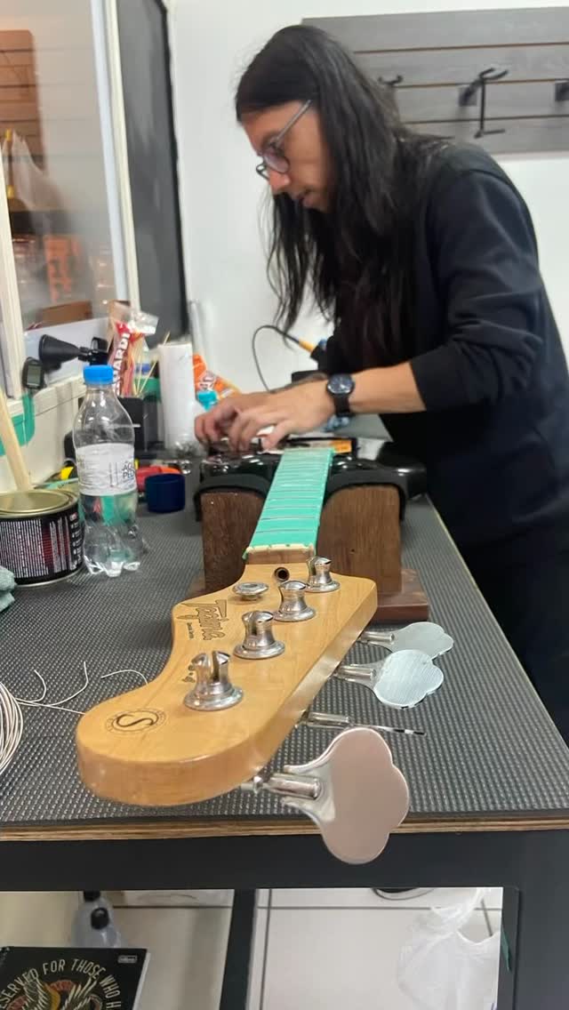 Luthier trabalhando na blindagem e manutenção de um baixo na bancada da Don Lauro